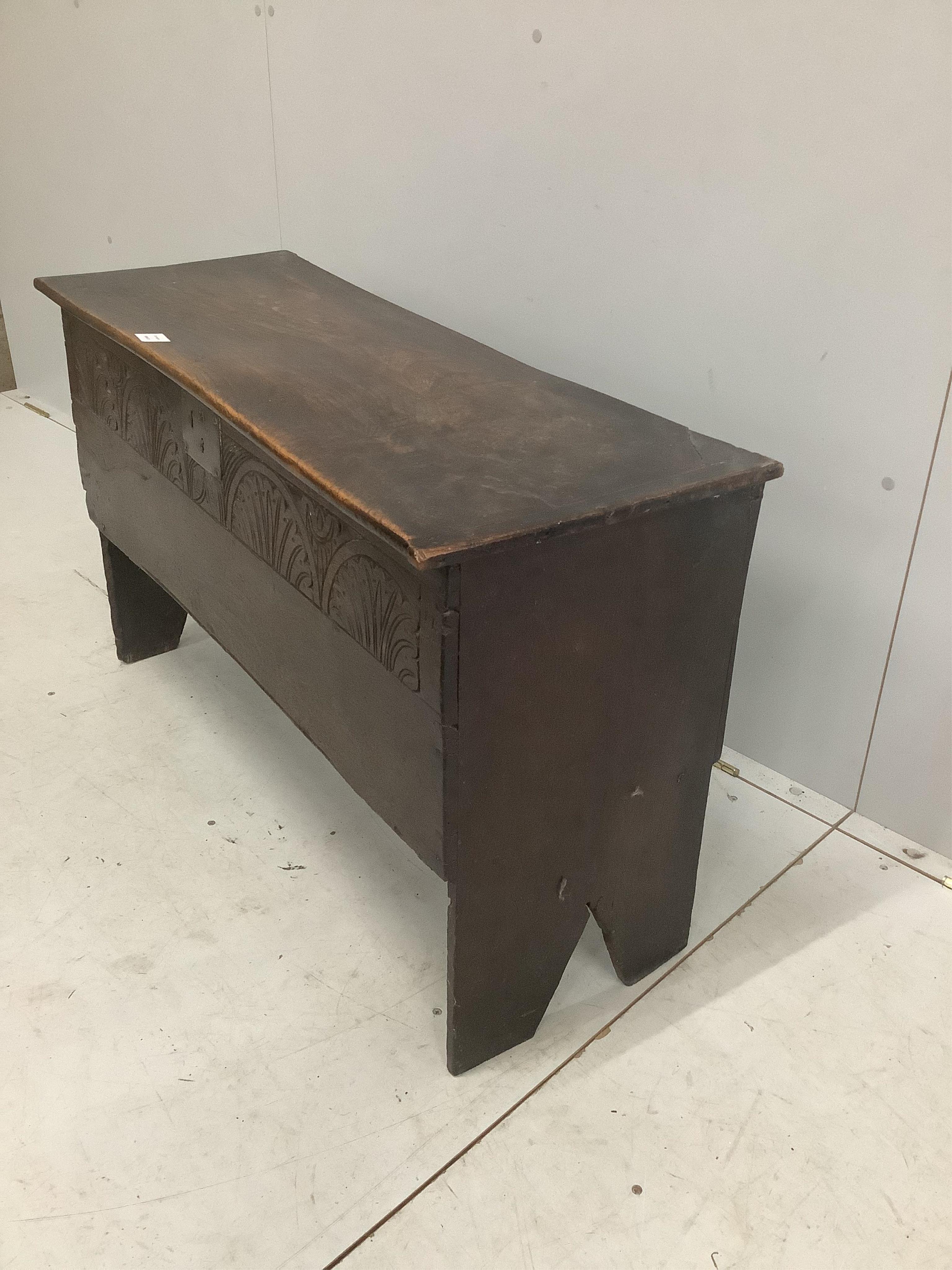 An early 18th century oak six plank coffer, with a lunette carved front, width 103cm, depth 38cm, height 61cm. Condition - fair